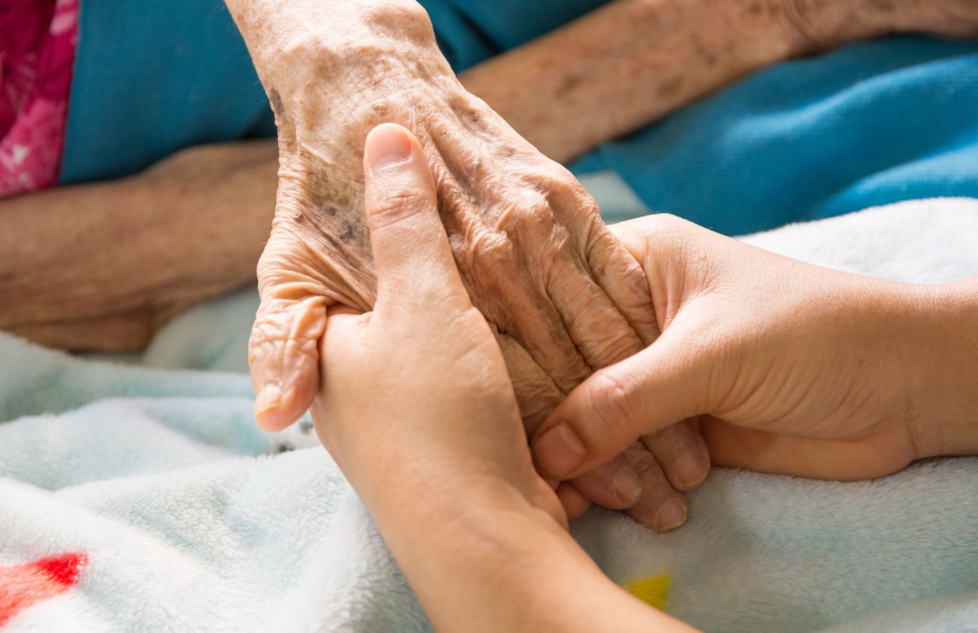 Hände halten die Hand eines älteren Menschen